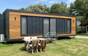 Moderna casa pequeña en el parque recreativo y marina Rhederlaagse Meren en Países Bajos con mesa exterior.