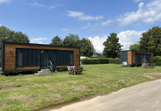 Zwei moderne Tiny Houses auf einer grünen Wiese im Erholungspark und Marina Rhederlaagse Meren, Niederlande.