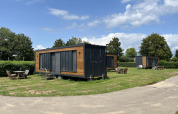 Casas Tiny House en el parque recreativo y marina Rhederlaagse Meren, Países Bajos, bajo un cielo azul.