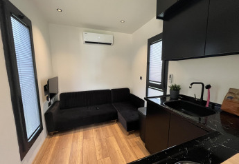 Modern living room and kitchen in a Tiny House lodge at Recreation park and Marina Rhederlaagse Meren, Netherlands.