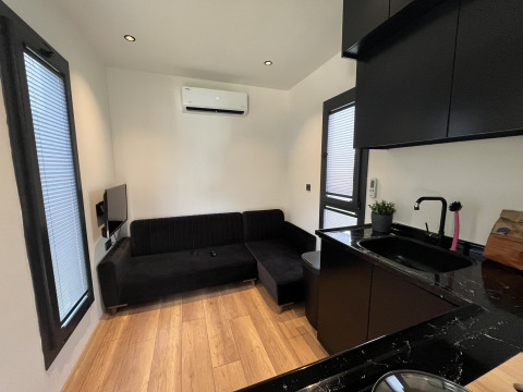 Moderne woonkamer en keuken in een Tiny House-lodge bij recreatiepark en Marina Rhederlaagse Meren.