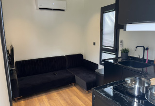 Moderne kleine woonkamer en keuken in een lodge, Tiny House bij Recreatiepark Rhederlaagse Meren.