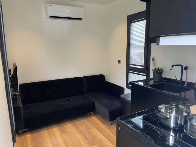 Moderne kleine woonkamer en keuken in een lodge, Tiny House bij Recreatiepark Rhederlaagse Meren.