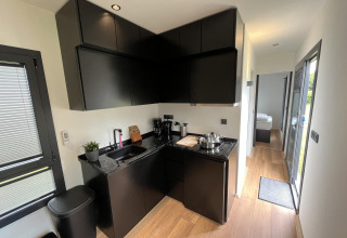 Modernes, schwarzes Miniküche in einem Tiny House im Freizeitpark und Marina Rhederlaagse Meren, Niederlande.