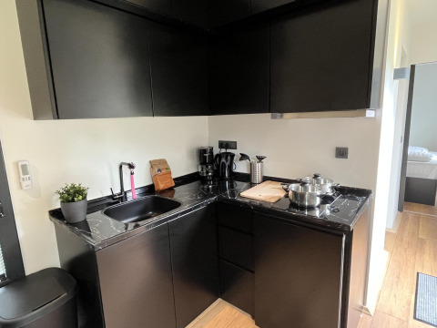 Moderne kleine zwarte keuken met marmeren werkblad in een Tiny House aan Rhederlaagse Meren, Nederland.