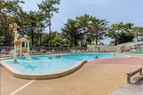 Outdoor swimming pool with slide and sun loungers at Camping Le Bois de la Gachère, Pays de la Loire, France.