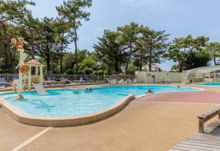 Außenpool mit Rutsche und Liegestühlen im Camping Le Bois de la Gachère, Pays de la Loire, Frankreich.