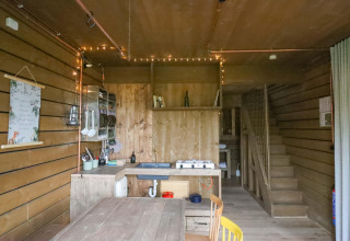 Cocina y comedor de madera en la tiny house Shelter + jacuzzi, Cosy Cabins, bosque de Limburg, Bélgica.