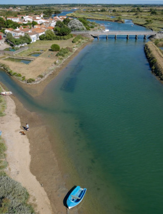 Luftfoto af en flod, lille landsby og bro i nærheden af Les Sables-d'Olonne, Pays de la Loire, Frankrig.