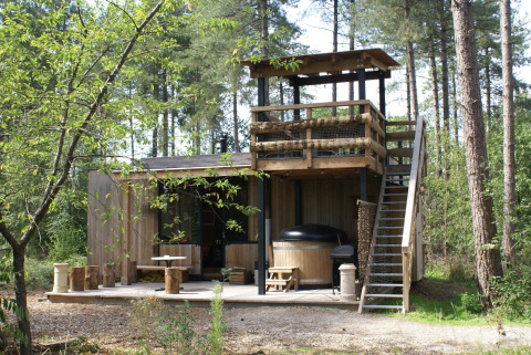Foto del Treetrunk lodge con bañera de hidromasaje exterior, terraza y plataforma en las Ardenas de Limburgo.