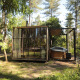 Cabane classique avec bain à remous chez Cosy Cabins, en forêt de Limburg, Belgique, entourée d’arbres.