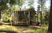 Classic cabin with hot tub at Cosy Cabins in the forests of Limburg, Belgium, surrounded by trees.