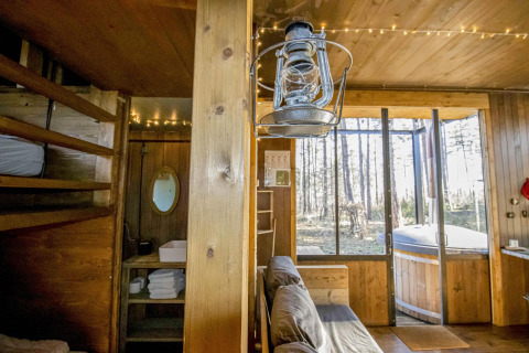Gemütliche Holzhütte im Wald mit Hochbett, Sofa, Retro-Laterne und Außen-Whirlpool in Limburg, Belgien.