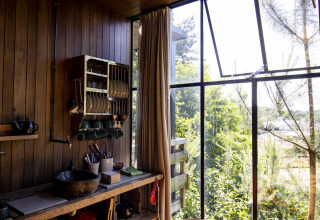 Rincón de cocina iluminado en Water Cabin + hot tub de Cosy Cabins en el bosque de Limburg, Bélgica.