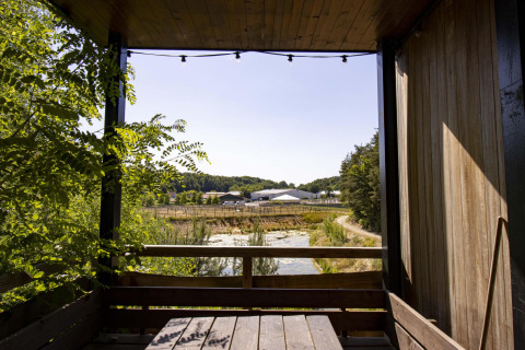 Blick aus der Water Cabin mit Whirlpool bei Cosy Cabins im Wald von Limburg, Belgien, mit Natur und Bauernhof.