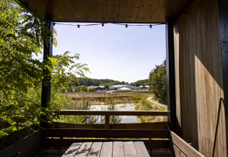 Blick aus der Water Cabin mit Whirlpool bei Cosy Cabins im Wald von Limburg, Belgien, mit Natur und Bauernhof.