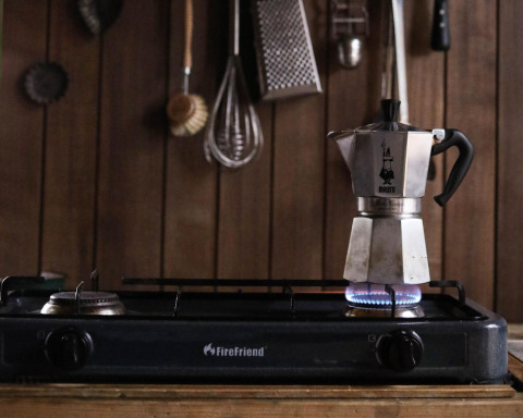 Una cafetera moka sobre una estufa de gas en la cocina de madera de Water cabin + hot tub en Limburgo, Bélgica.