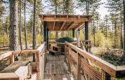 Træhus med spabad og overdækket terrasse i en skov i Limburg, Belgien, set fra gangsti.
