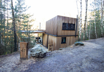 Cabina moderna in legno Comfort Sweet + hot tub immersa nella foresta, circondata da natura e betulle.