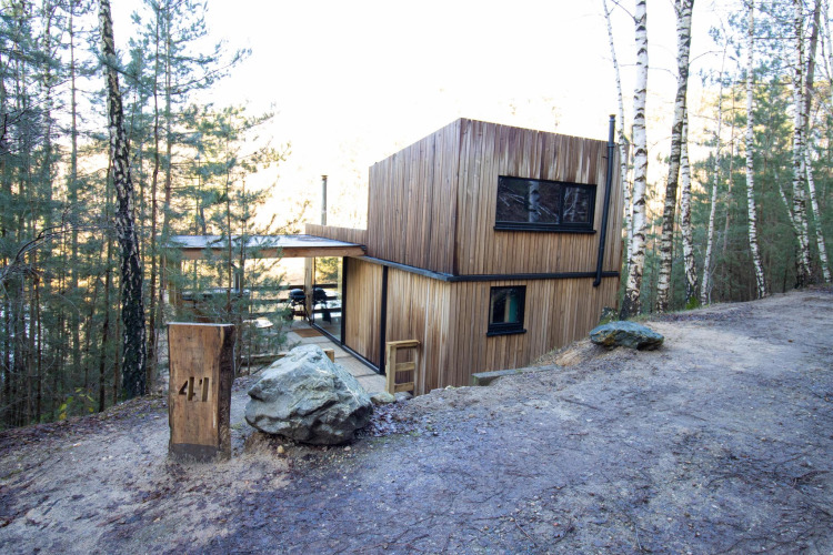 Cabaña de madera moderna Comfort Sweet + hot tub situada en el bosque, rodeada de naturaleza y abedules.