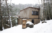Cabane Comfort Sweet avec bain chaud dans la forêt enneigée du Limbourg, Belgique, entourée de bouleaux.