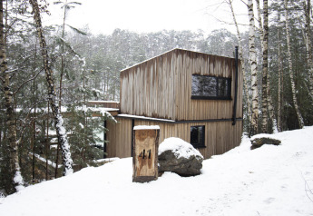 Cabane Comfort Sweet avec bain chaud dans la forêt enneigée du Limbourg, Belgique, entourée de bouleaux.