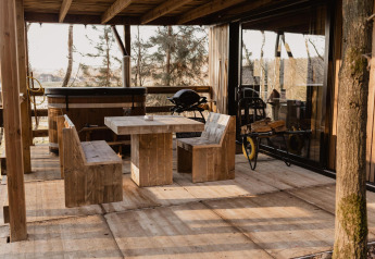 Terrazza esterna al Comfort Sweet + vasca idromassaggio a Cosy Cabins nella foresta di Limburg, Belgio.