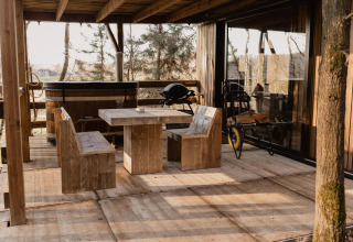 Terrazza esterna al Comfort Sweet + vasca idromassaggio a Cosy Cabins nella foresta di Limburg, Belgio.