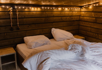 Camera accogliente in legno con letto matrimoniale e luci calde, Comfort Sweet, Limburg, Belgio.