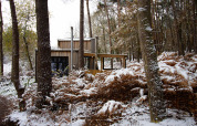 Cabaña Comfort Classic + hot tub de Cosy Cabins, situada en un bosque nevado de Limburgo, Bélgica.