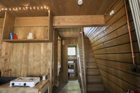Vista interior de la cabaña Comfort Classic con paredes de madera y escalera en Cosy Cabins, bosque de Limburg.