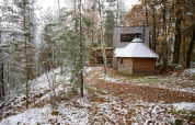 Comfort Classic + sauna cottage di Cosy Cabins immerso in una foresta innevata a Limburg, Belgio.