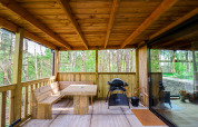 Terraza cubierta de madera con banco, mesa y barbacoa en Comfort Classic + sauna en el bosque de Limburgo, Bélgica.