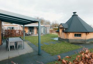Buitenruimte met grillhuisje, overdekt terras en Veluwe Villa met sauna bij park De Boshoek, Nederland.