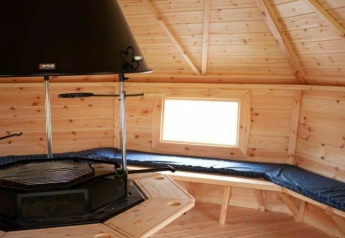 Vue intérieure de la Veluwe Villa avec plafond en bois et grill au Holiday park De Boshoek, Pays-Bas.