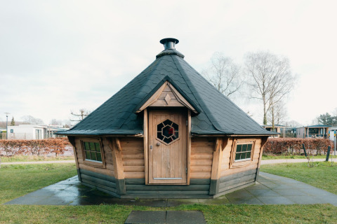 Houten lodge met zwart dak aan Veluwe Villa + sauna op Holiday park De Boshoek in Nederland.