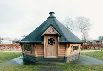 Houten lodge met zwart dak aan Veluwe Villa + sauna op Holiday park De Boshoek in Nederland.