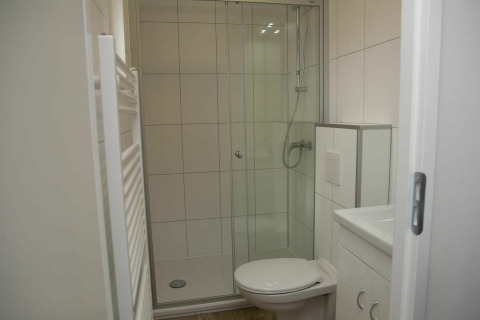 Moderne badkamer met glazen douche, toilet en wit meubilair bij Veluwe Villa + sauna, De Boshoek.