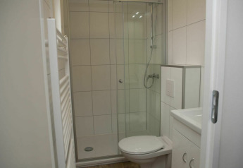 Baño moderno con ducha de cristal, inodoro y muebles blancos en Veluwe Villa + sauna, De Boshoek.