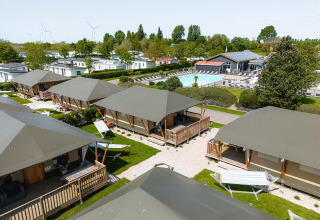 Vista de Villatent Cottage en Camping de Molenhoek, Países Bajos, con tiendas, piscina y zonas verdes.