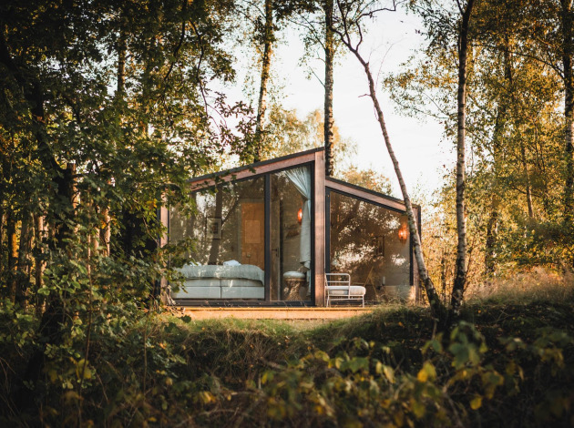 Moderne glazen lodge Cabin on the Hill bij Wilsumer Berge, Duitsland, gelegen tussen bomen en natuur.