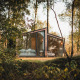 Modern glass cabin named Cabin on the Hill at Wilsumer Berge, Germany, nestled peacefully among trees.