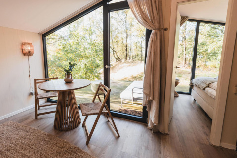 Interno luminoso e moderno di Cabin on the Hill con ampie vetrate e vista sulla natura a Wilsumer Berge.