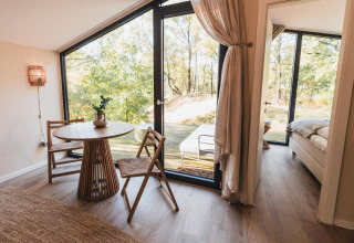 Lyst og moderne interiør i Cabin on the Hill med store vinduer og udsigt til naturen i Wilsumer Berge.
