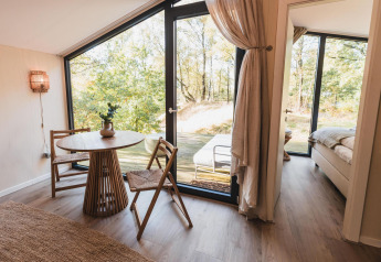 Helles Interieur der Cabin on the Hill mit großen Fenstern und Blick ins Grüne bei Wilsumer Berge.