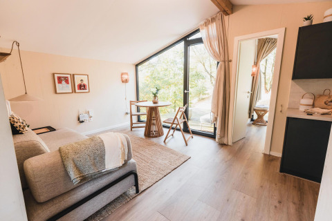 Lichte, gezellige woonkamer in Cabin on the Hill, Wilsumer Berge, Duitsland, met modern interieur en grote ramen.