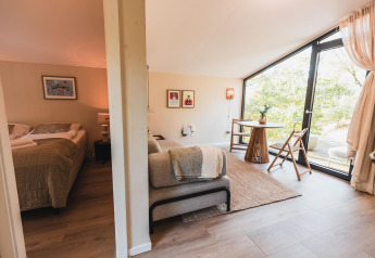 Moderne Lodge Cabin on the Hill bei Wilsumer Berge in Deutschland mit Schlafzimmer und Wohnraum.