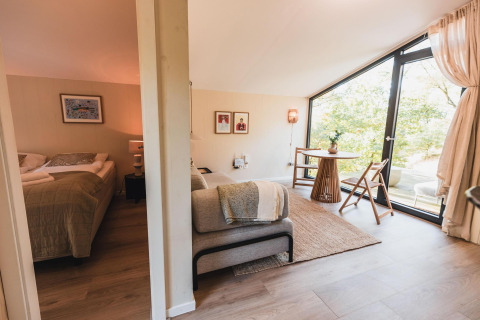 Moderna cabaña Cabin on the Hill en Wilsumer Berge, Alemania, con dormitorio y sala de estar acogedora.