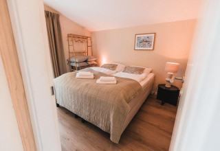 Dormitorio en Cabin on the Hill en Wilsumer Berge, Alemania, con cama doble y luz ambiental suave.