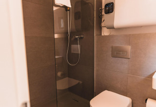 Bagno moderno con WC sospeso, doccia in vetro e scaldabagno in Cabin on the Hill, Wilsumer Berge.